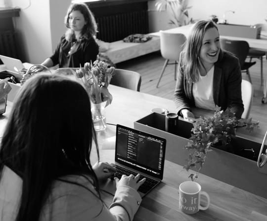 3 girls sitting at the computer in the office