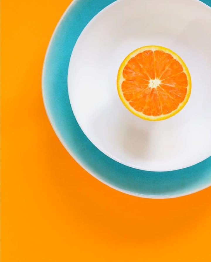 orange in a plate on an orange-colored table