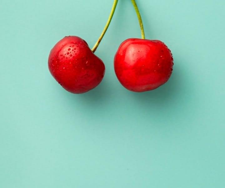 red cherry close up on a green background